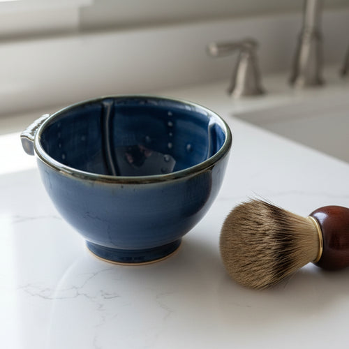 Ceramic bowl with blue interior and silver rim on a white background